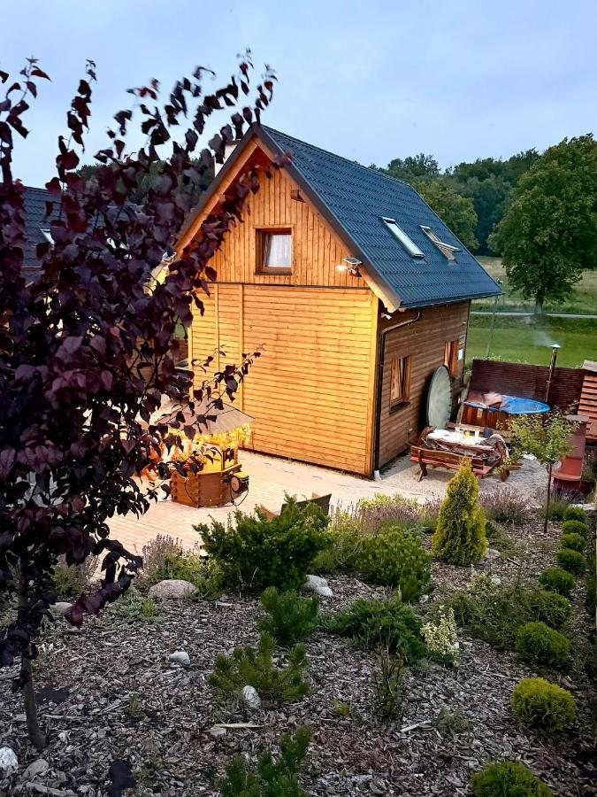 Domki na Kaszubach – drewniany dom Siedliska Złota Góra w ogrodzie o zmierzchu