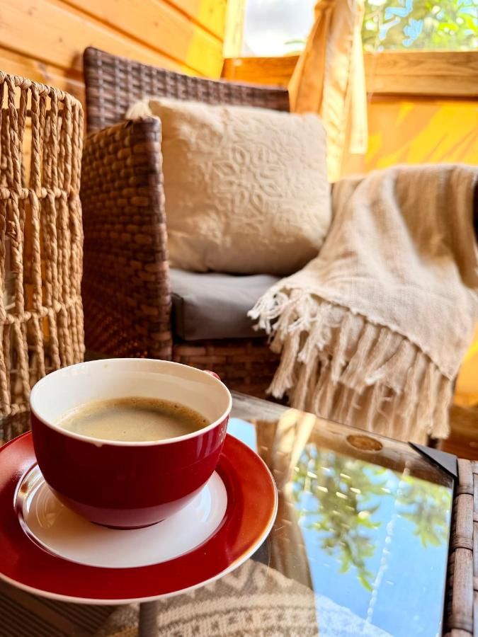 Kawa na tarasie, rattanowy fotel i koc z frędzlami