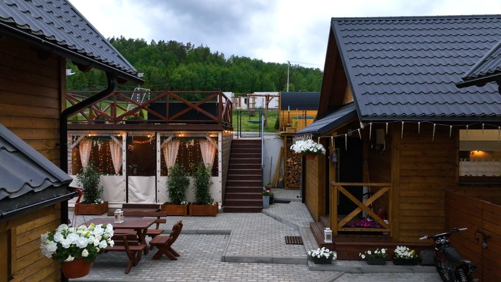 Dziedziniec siedliska wieczorem, oświetlona wiata – weekend z przyjaciółmi na Kaszubach