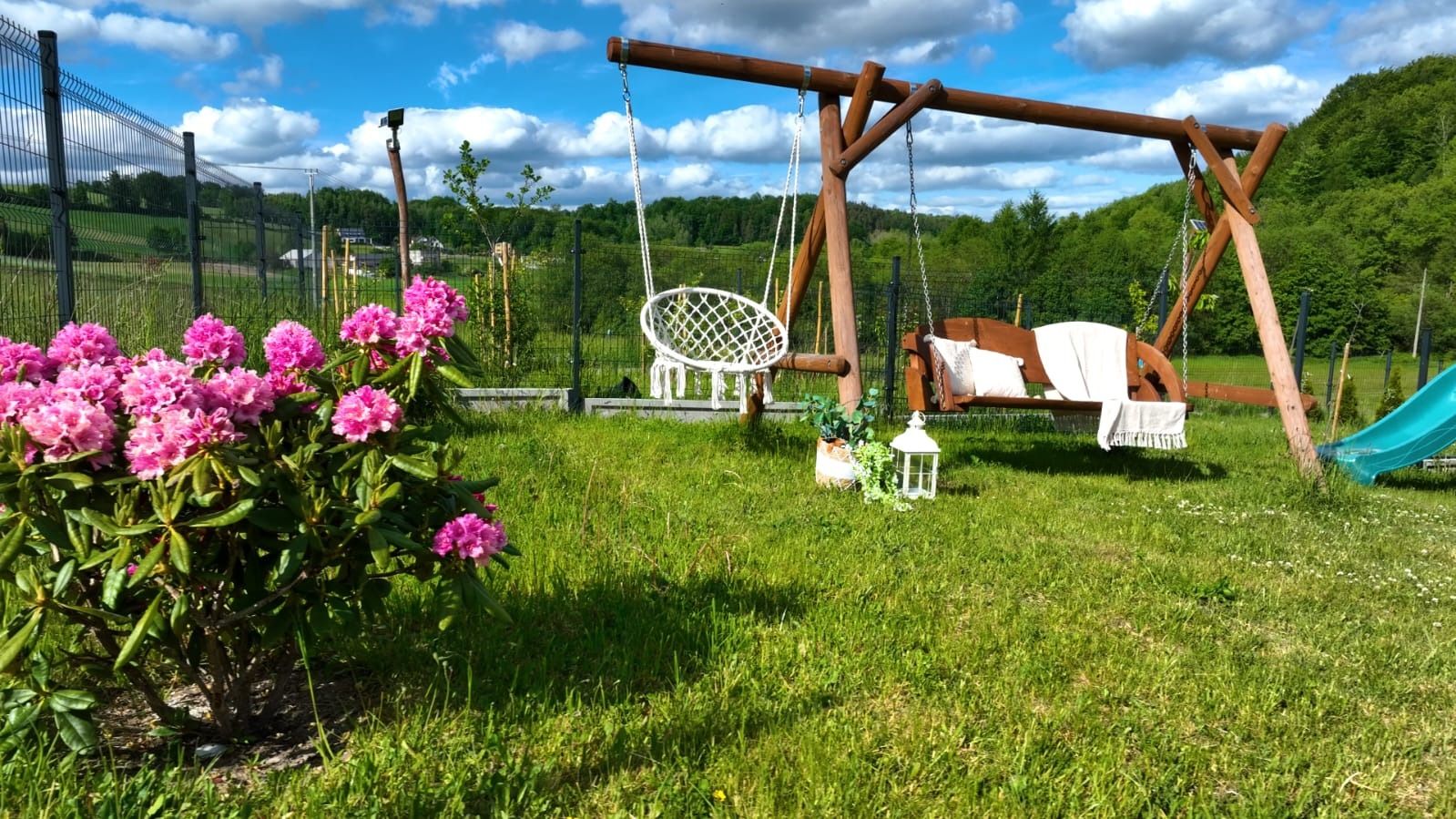 Huśtawki w ogrodzie wśród rododendronów