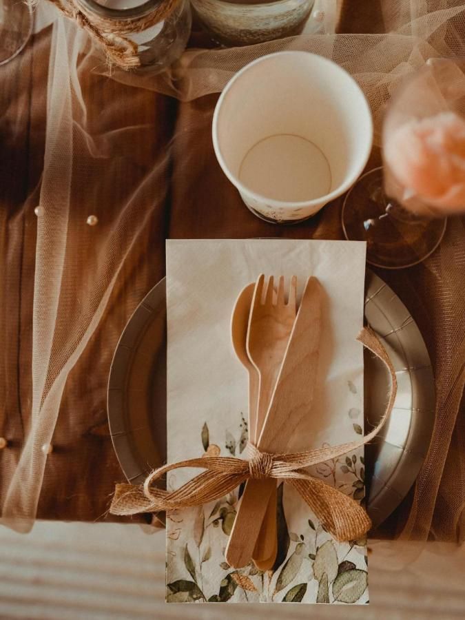Stół nakryty drewnianymi sztućcami i lnianą serwetką